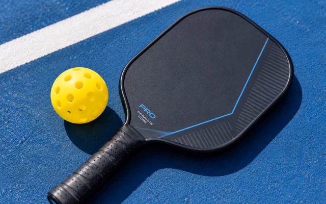 How to choose a pickleball paddle - paddle and ball on court